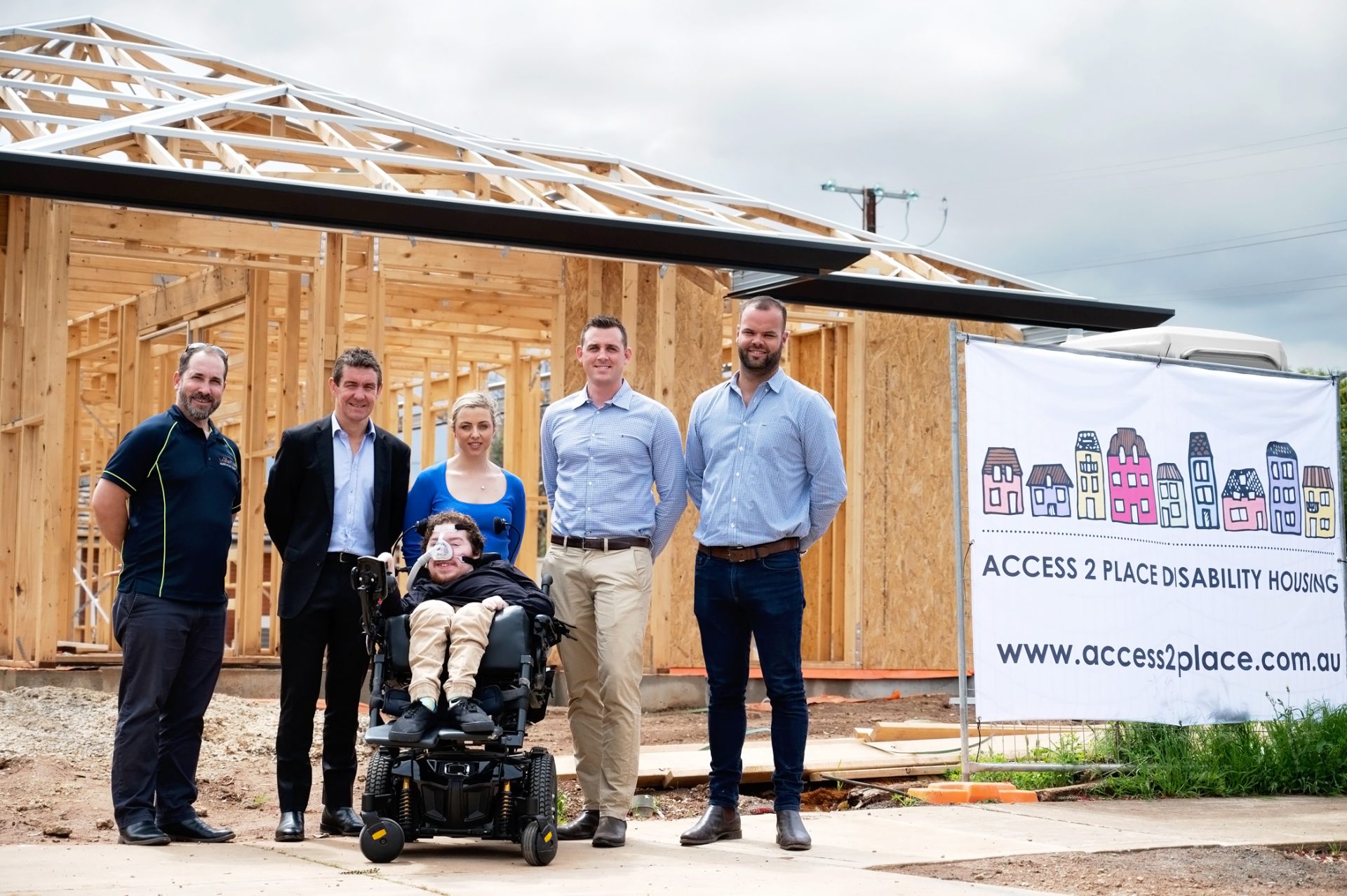 The Access 2 Place team with one of their tenants in front of a new purpose built project.